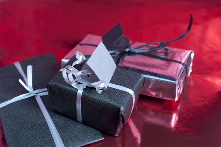 three small christmas presents wrapped with a bow of ribbon
