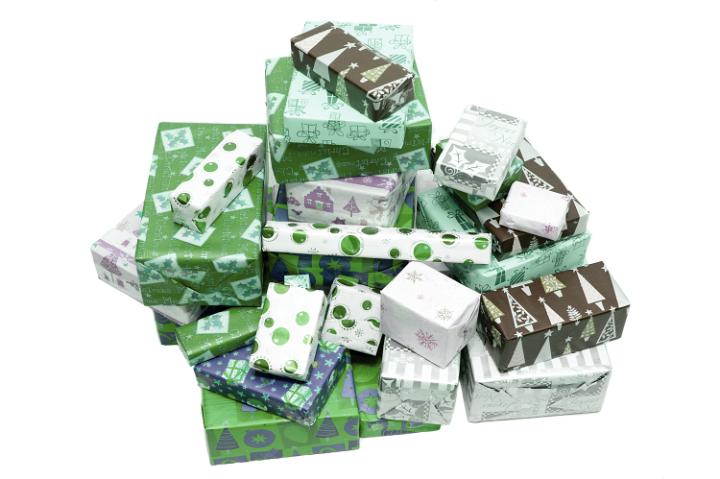 Heap of green themed wrapped christmas gifts for a family celebration on a white background viewed high angle