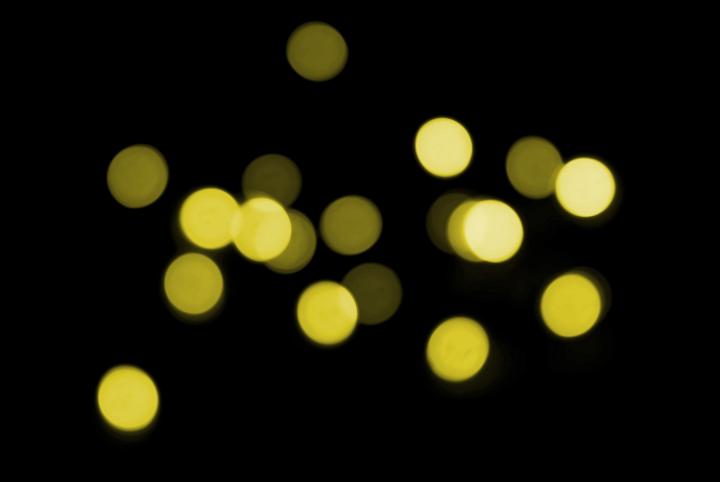 a backdrop of yellow glowing bokeh (defocused lens effect) lights