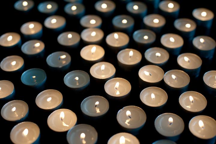 a background of burning tealight candles on a back background