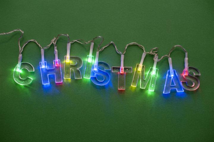 Christmas garland spelling out christmas in coloured light on green background