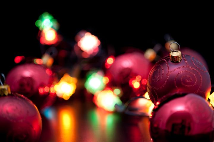 Brightly coloured party lights illuminating Christmas baubles and decorations in the foreground